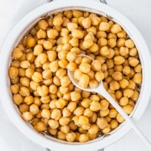 cooked chickpeas in a white sift with white spoon