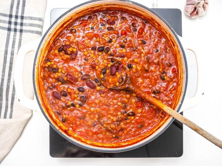 lentil chili in a casserole with a wooden spoon