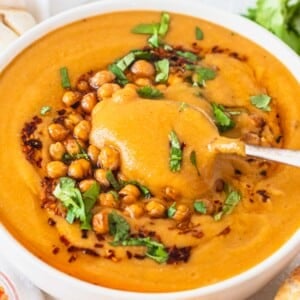 Turkish red lentil soup with silver spoon and roasted chickpeas