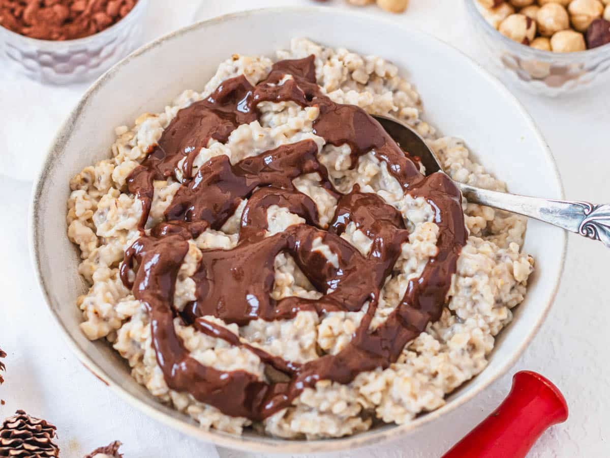hazelnut spread on oatmeal with chia seeds in a white bowl