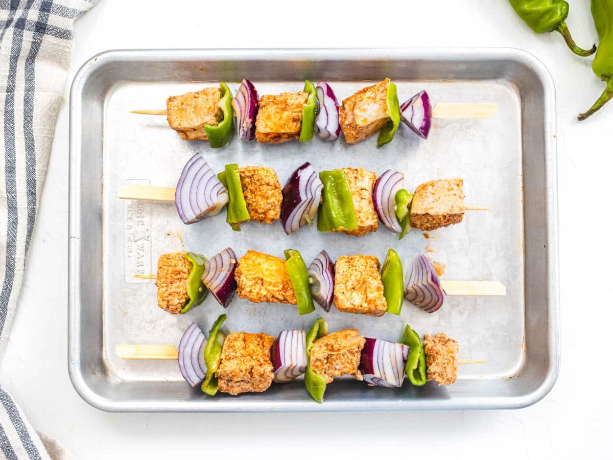 tofu skewers with red onion on a baking tray