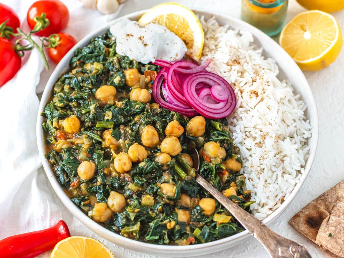 Chana Saag with basmati rice in a white bowl and a spoon