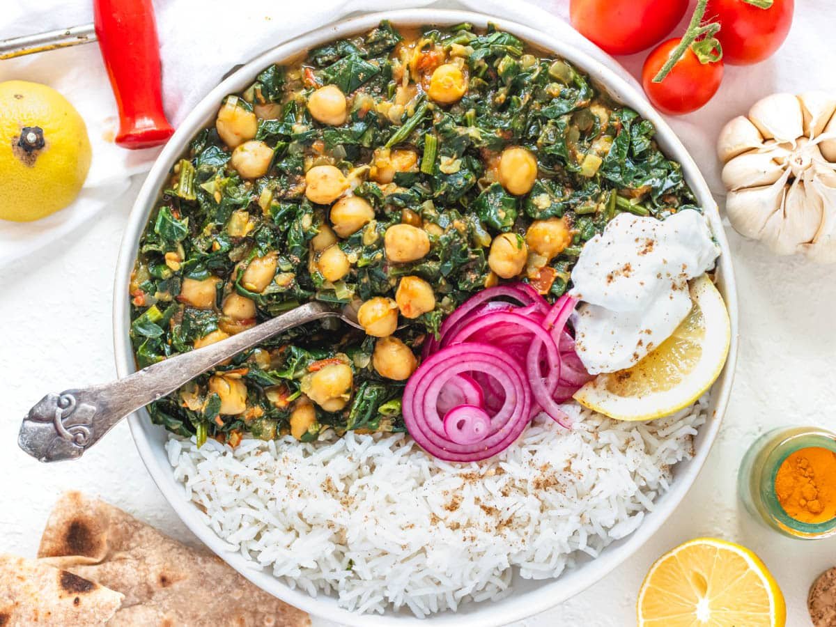 Chana Saag with pickled red onions and a silver spoon