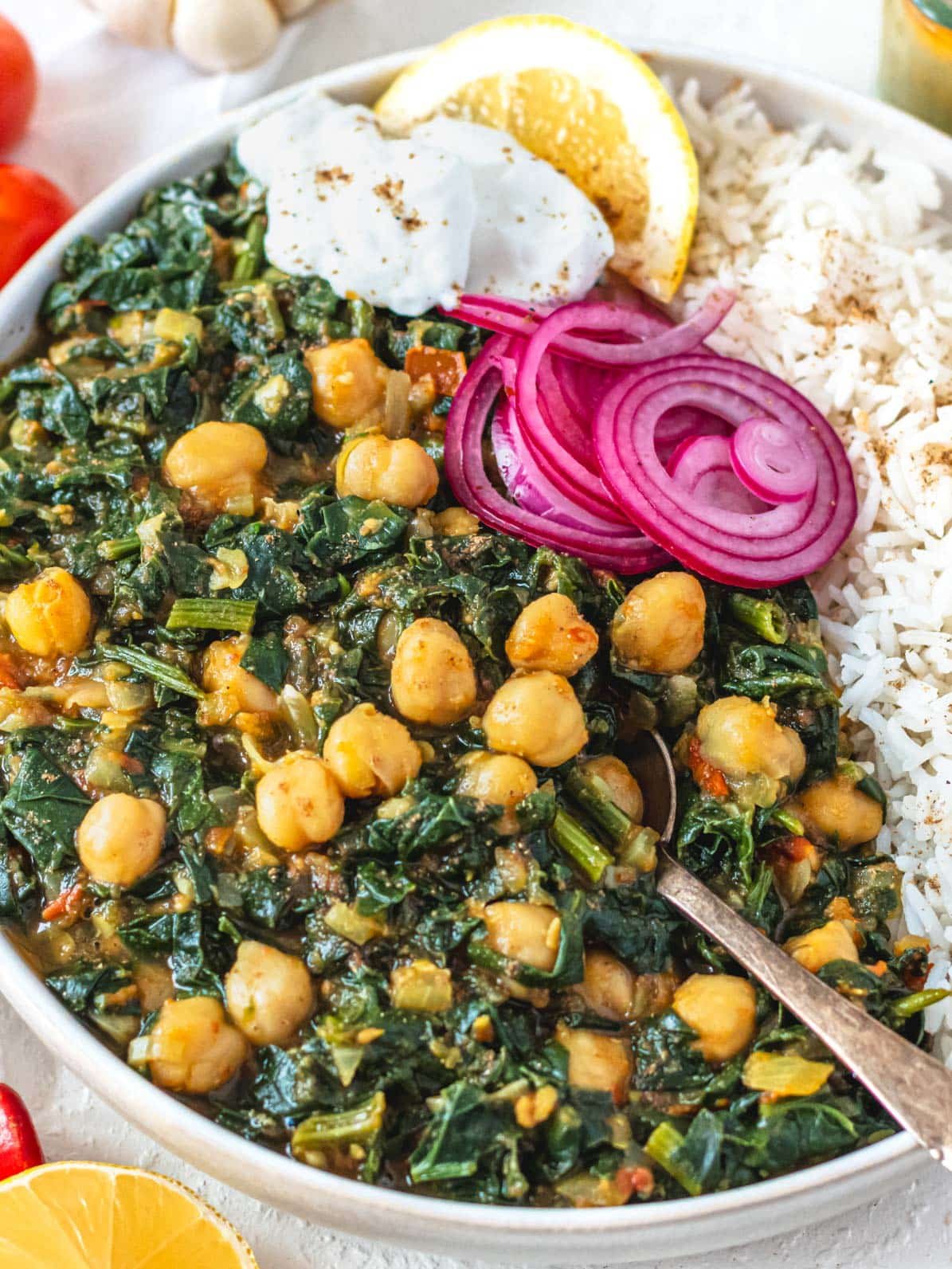 Chana Saag with white rice, pickled red onions and a spoon
