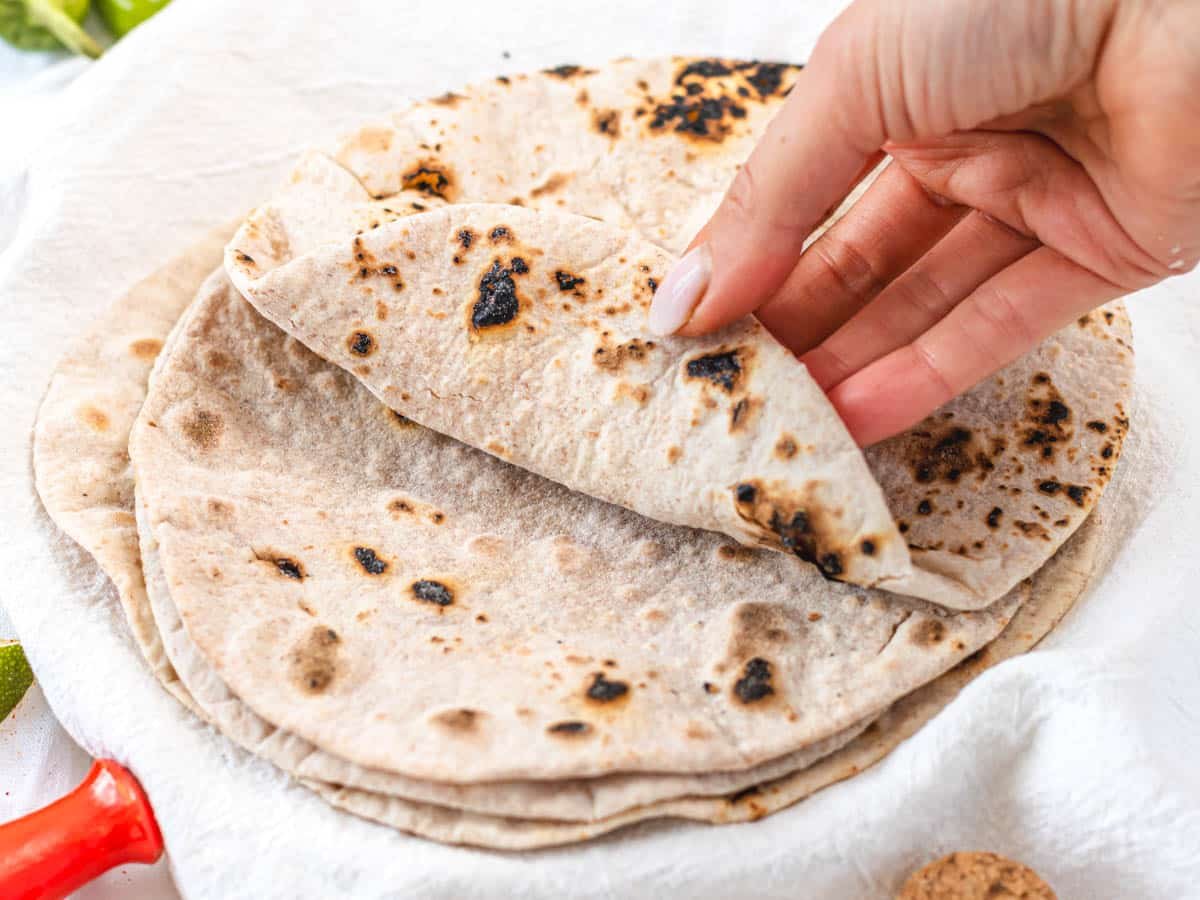 Charred roti flatbread with a hand