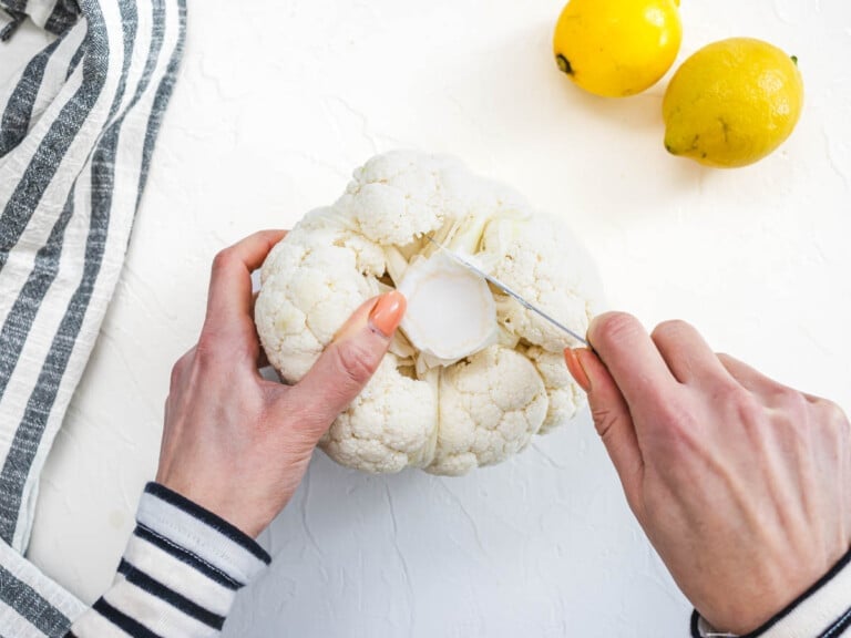 hands trimming of head of cauliflower with a pairing knife
