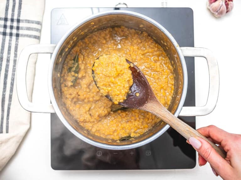 red lentils and a wooden spoon in a silver pot