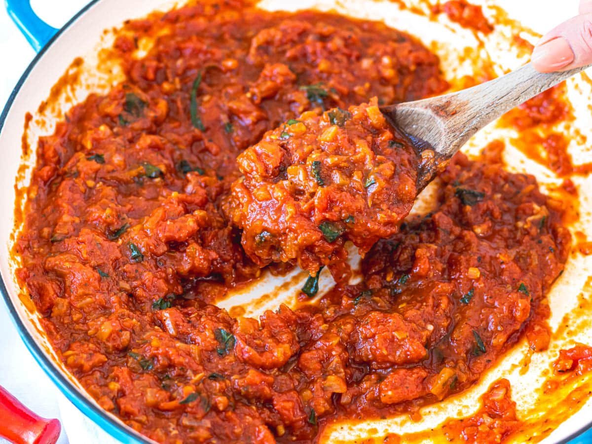 Marinara sauce with basil and a wooden spoon