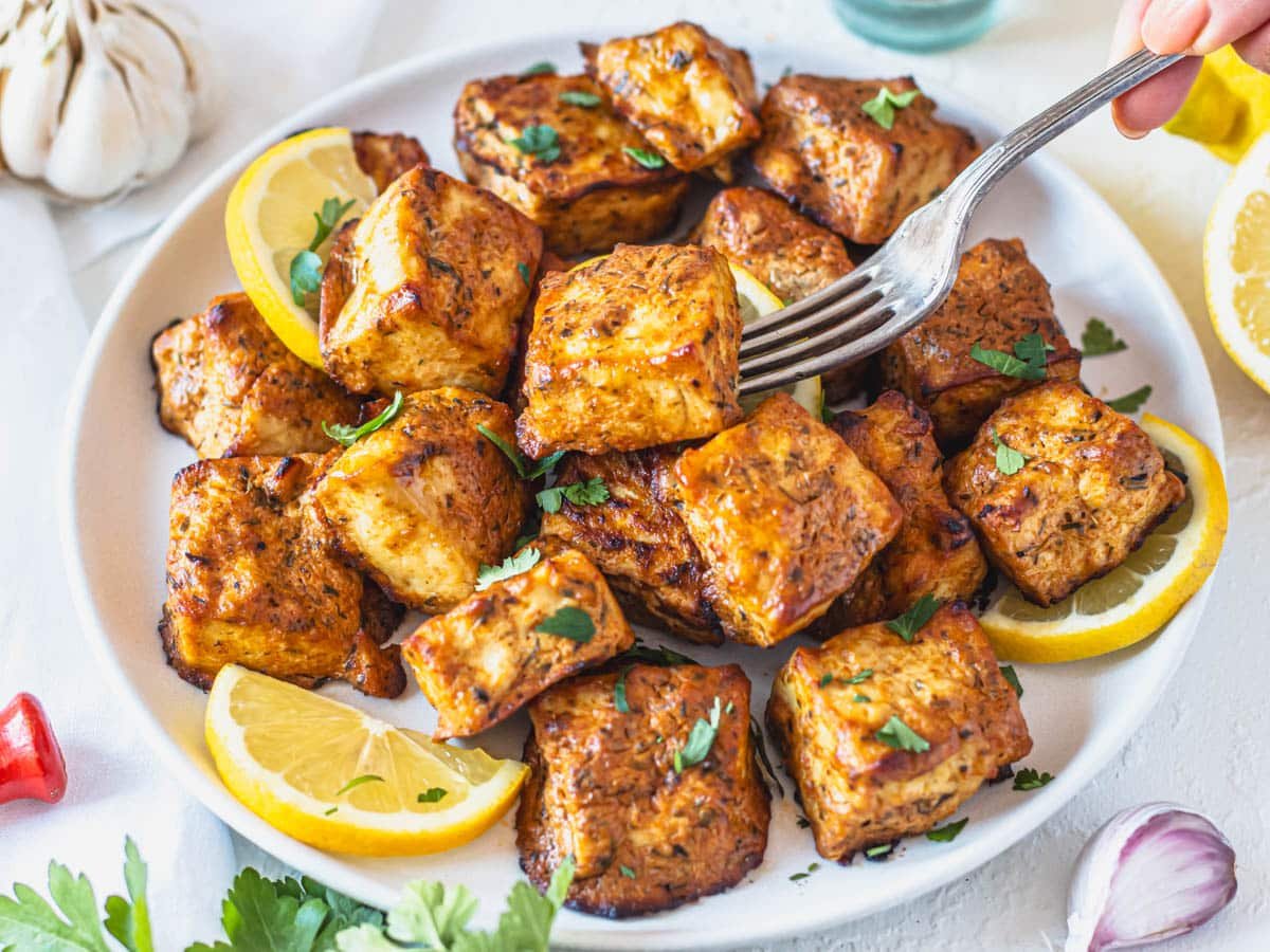 Marinated tofu with lemon and parsley and a silver fork