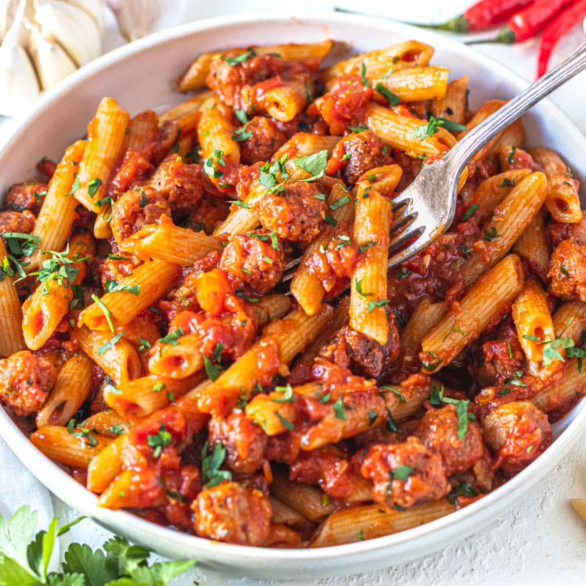 Penne with arrabbiata sauce and a silver fork in the pasta