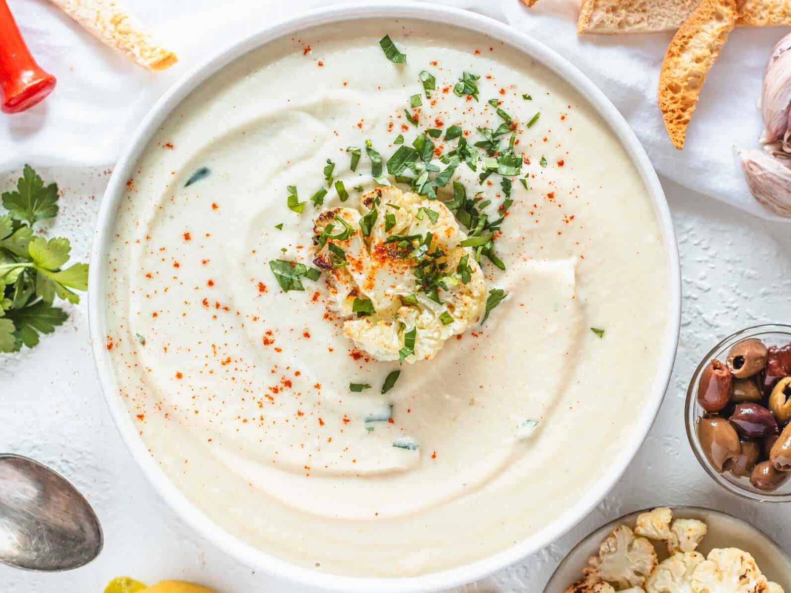 Roasted cauliflower soup with pita chips, olives and fresh herbs