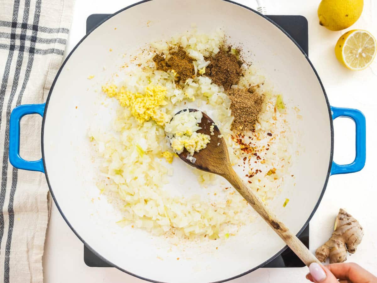 spice mix and chopped onions in a skillet with a wooden spoon