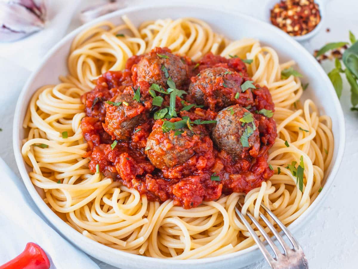 Vegan meatballs with marinara sauce and spaghetti in a bowl