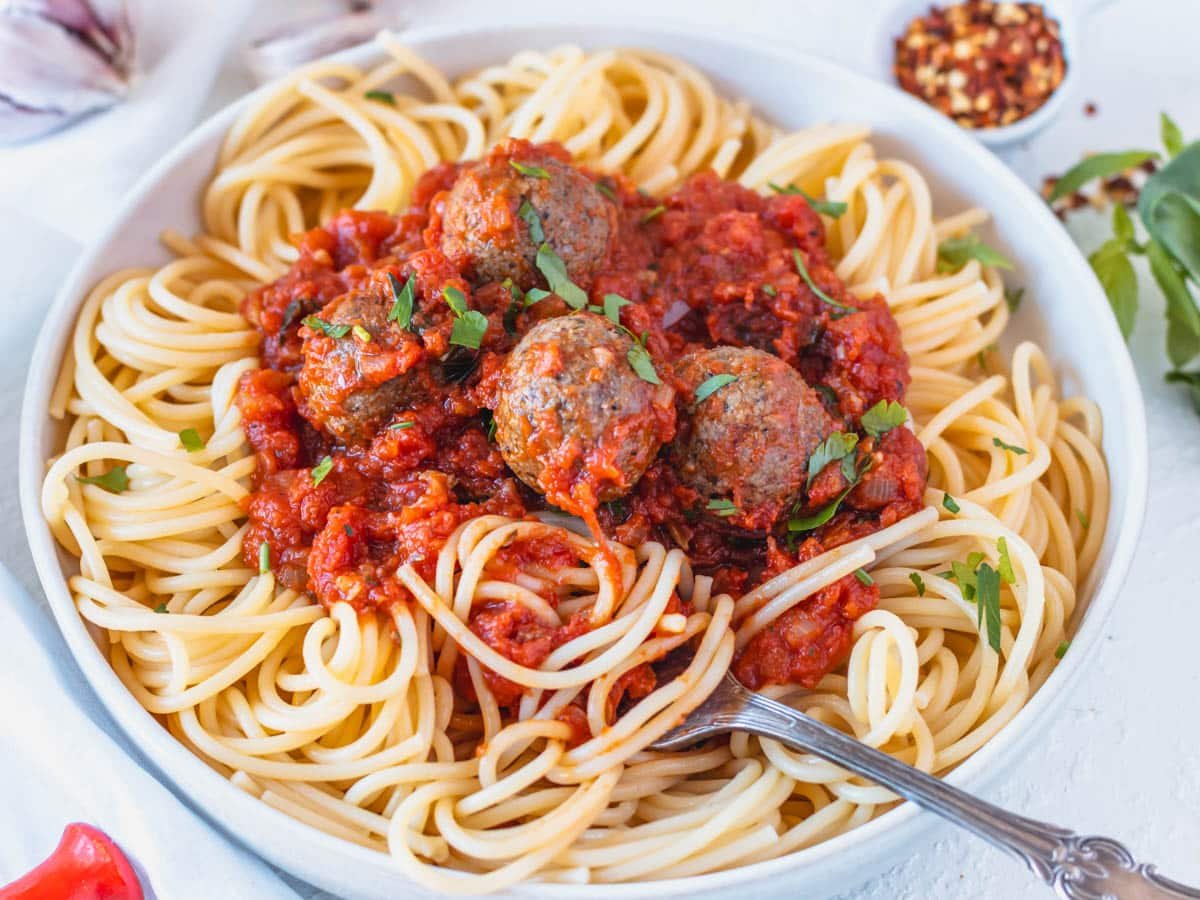 Vegan meatballs on spaghetti with a silver fork