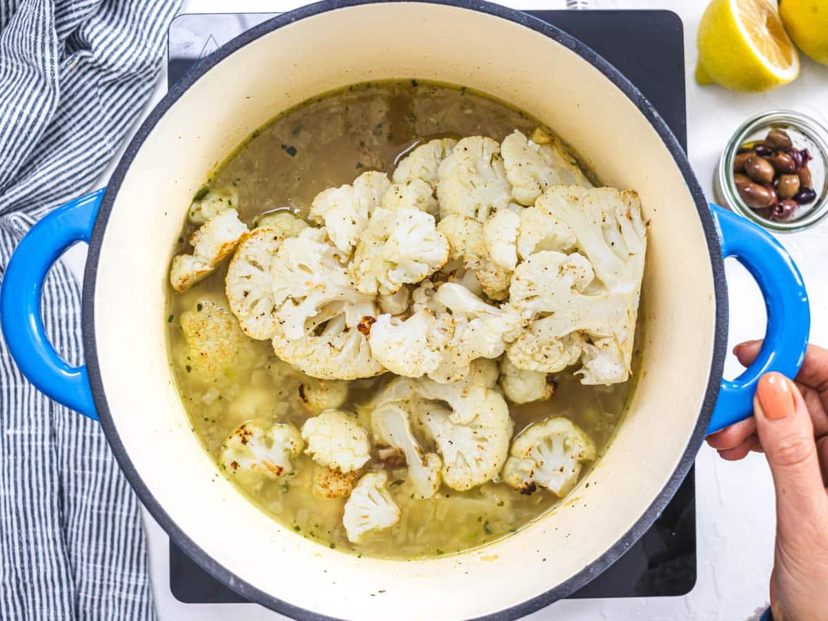 roasted cauliflower added to vegetable broth in a casserole