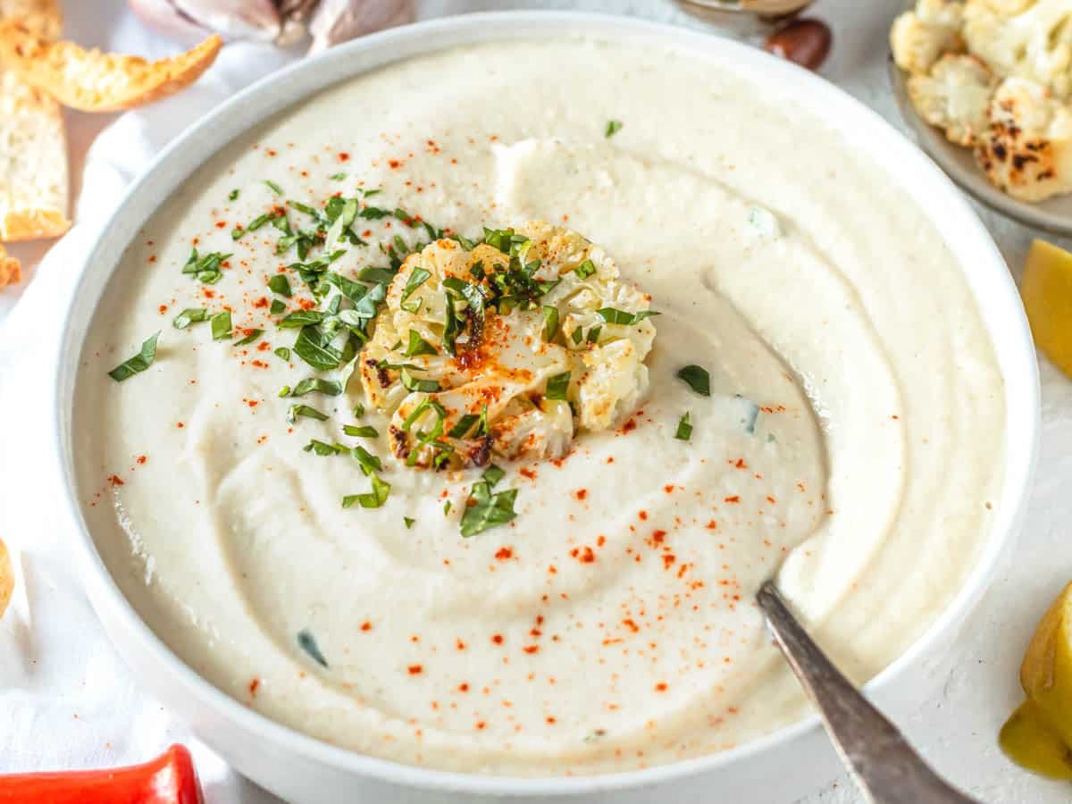 cauliflower soup with a floret of roasted cauliflower and a spoon