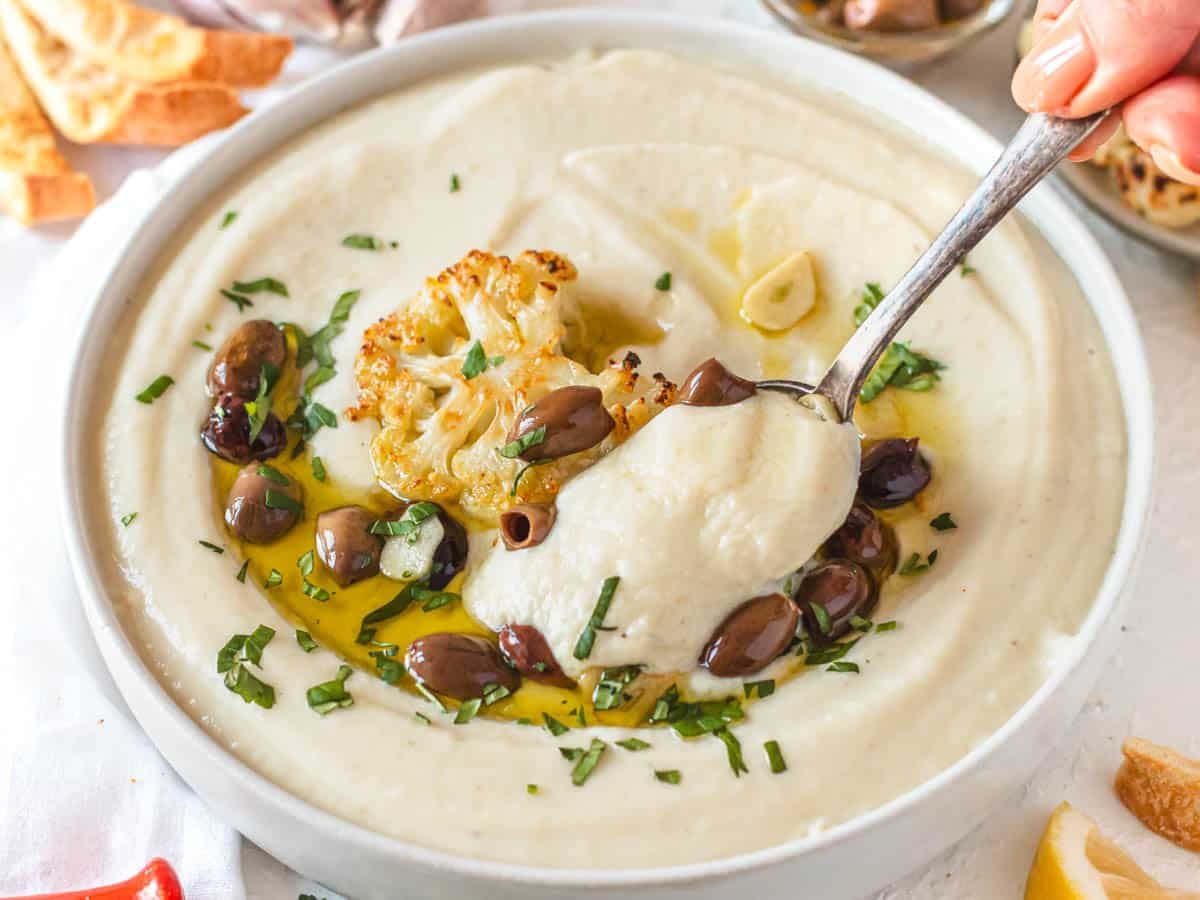 cauliflower soup with handing a silver spoon