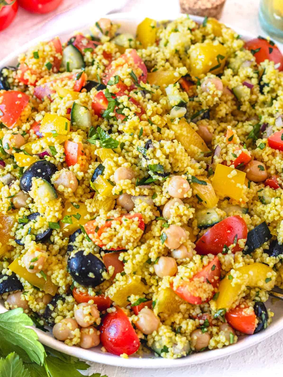 easy couscous salad with olives, cherry tomatoes and chickpeas on a plate