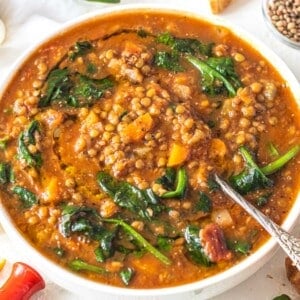 Lentil vegetable soup with spinach and a silver spoon