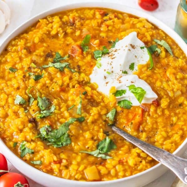 Mung Dal with fresh cilantro and a dollop on yogurt in a white bowl