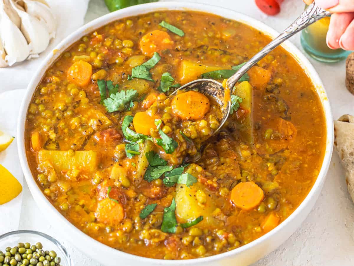 Mung bean soup with a silver spoon and fresh cilantro