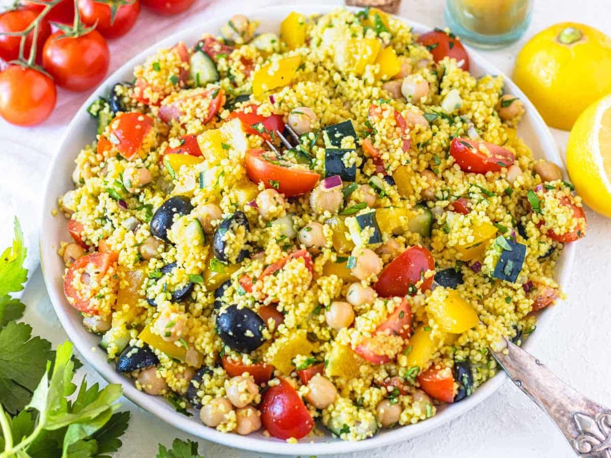 easy couscous salad on a white plate with a silver fork