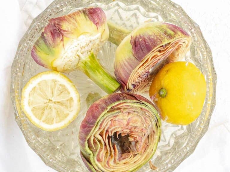 artichokes in a bowl with cold water and lemon