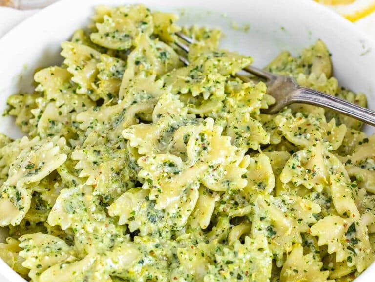 Arugula pesto with bowtie pasta and a silver fork