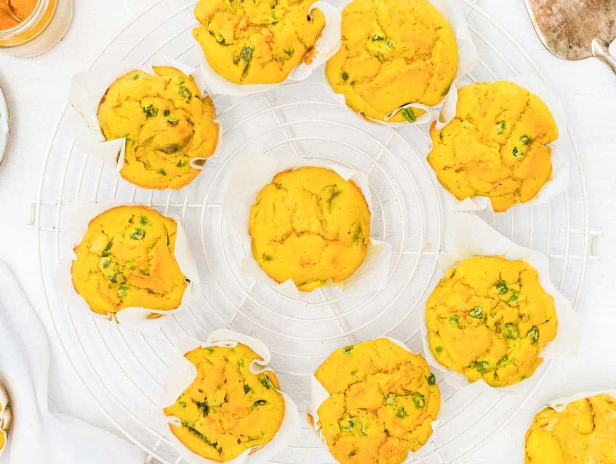 Chickpea Muffins on a cooling rack with peas and cauliflower