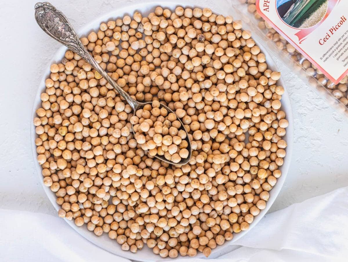 small dried chickpeas on a plate with a silver spoon
