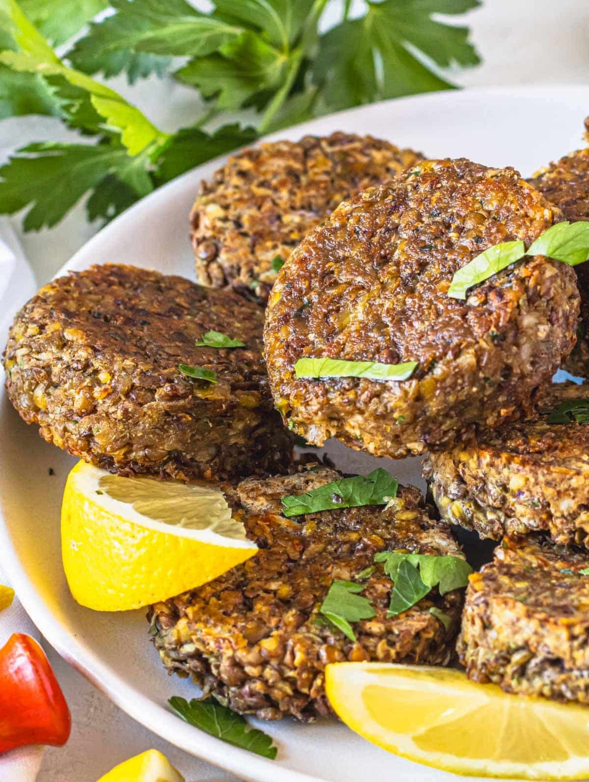 Lentil patties on a plate with parsley and lemon