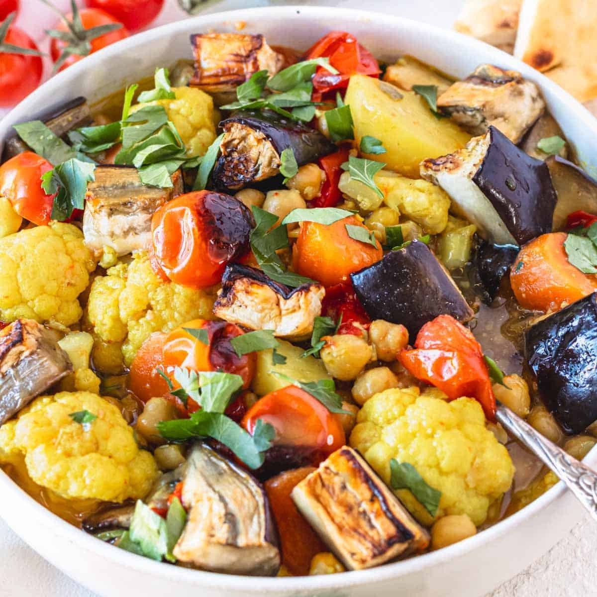 Vegetable stew with a silver spoon in a white bowl
