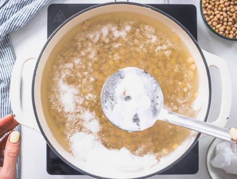 chickpeas cooking in a white pot with foam