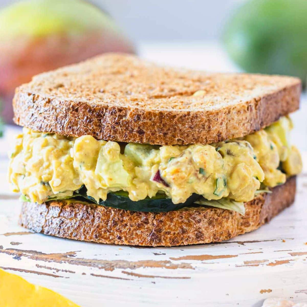 curry chickpea salad in a sandwich with lettuce and cucumber