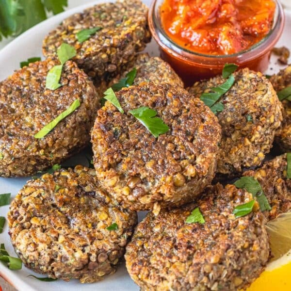 lentil patties stacked on a plate and served with dipping sauce