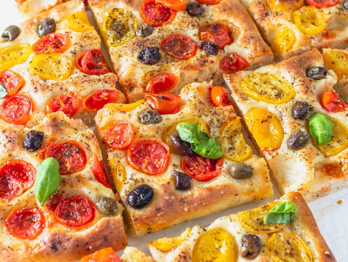 Focaccia pizza cut into slices with olives