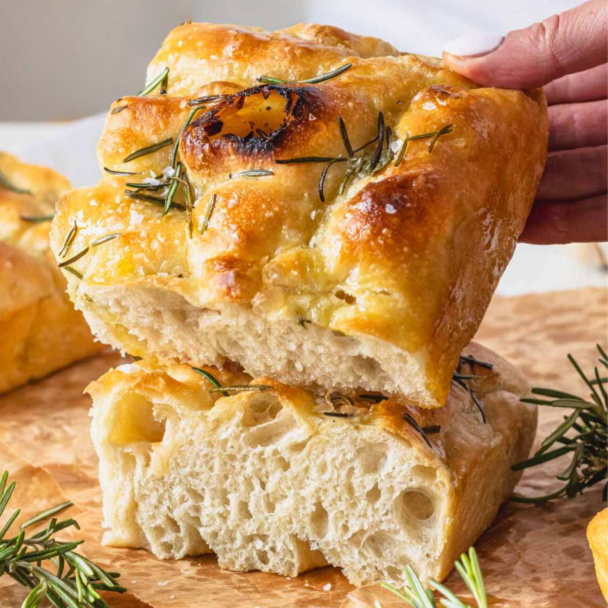 Focaccia with rosemary and a hand