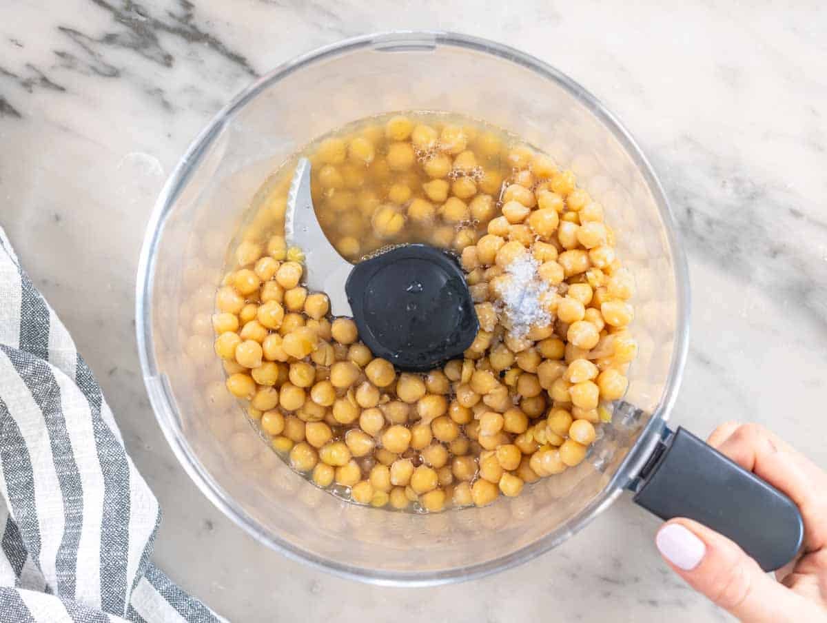 chickpeas and chickpea water in a food processor