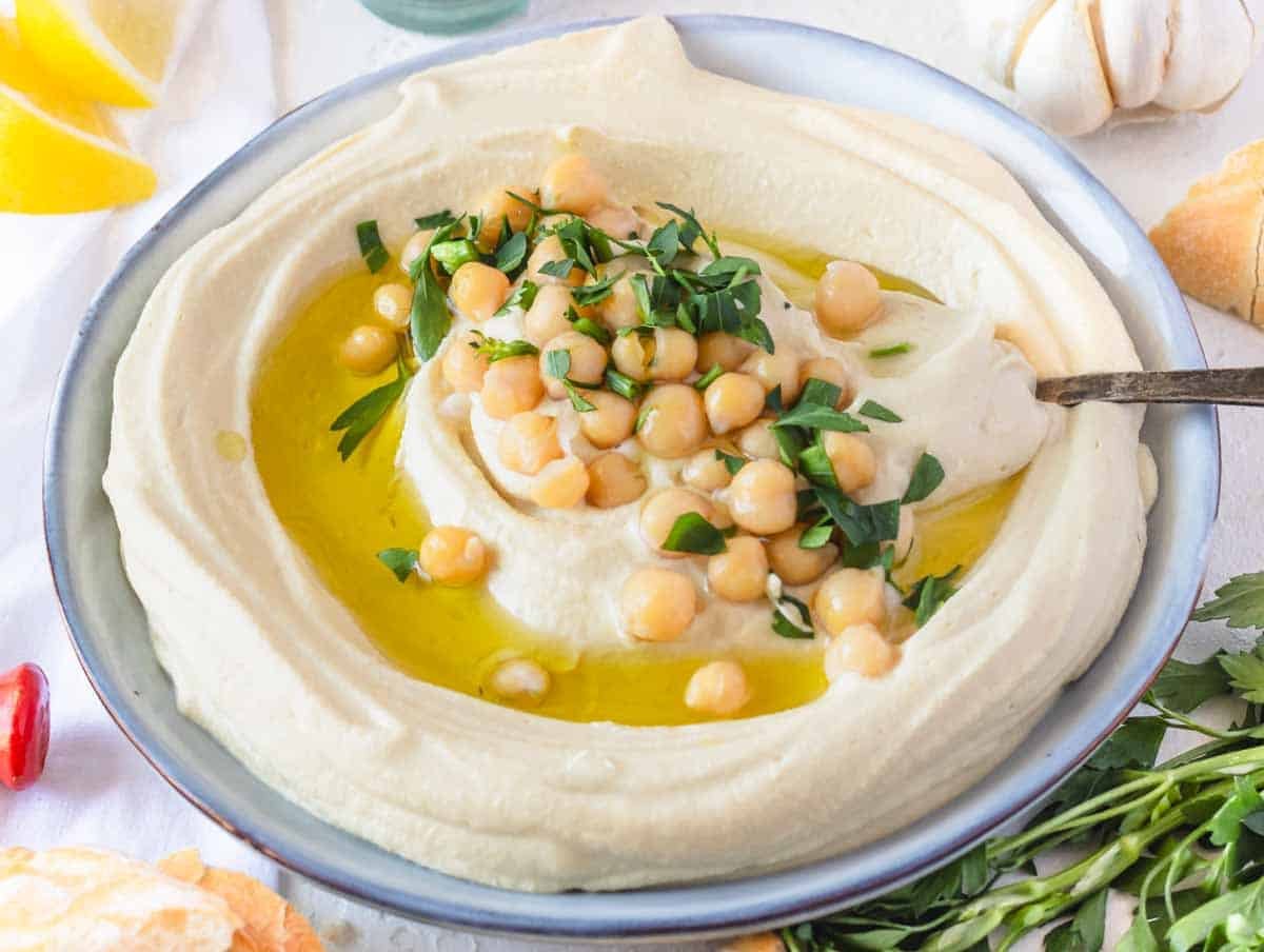 Hummus on a plate with a silver spoon