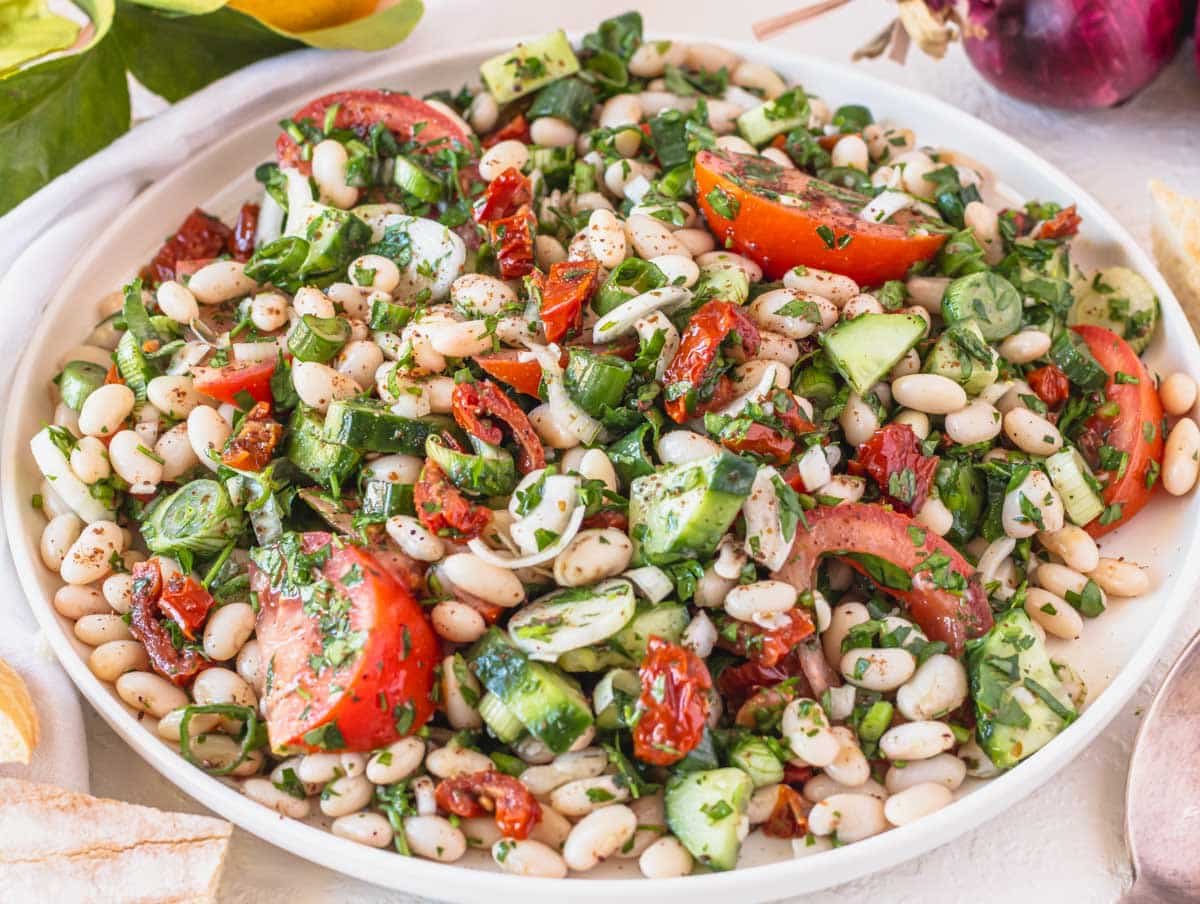 White bean salad with vine tomatoes on a white plate