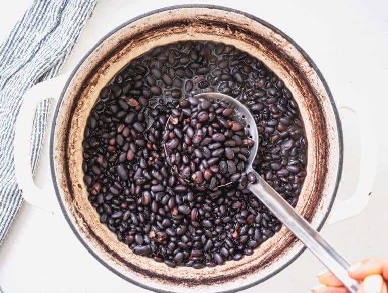 black bean after cooking in a white pot and a silver spoon