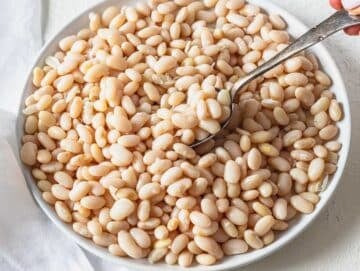 white bean with a silver spoon on a white plate