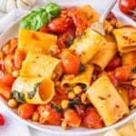 paccheri pasta with cherry tomatoes and fresh basil on a white plate