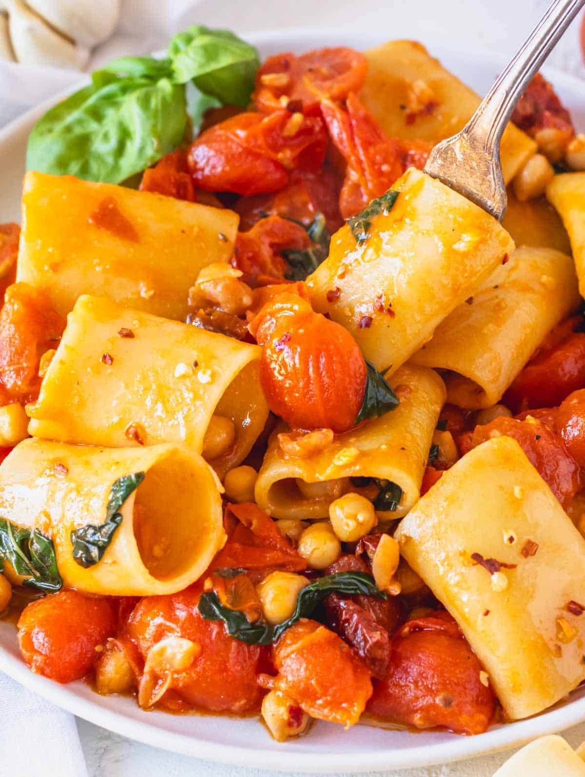 paccheri pasta with cherry tomatoes on a white plate