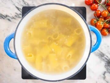 paccheri pasta cooking in a blue pot