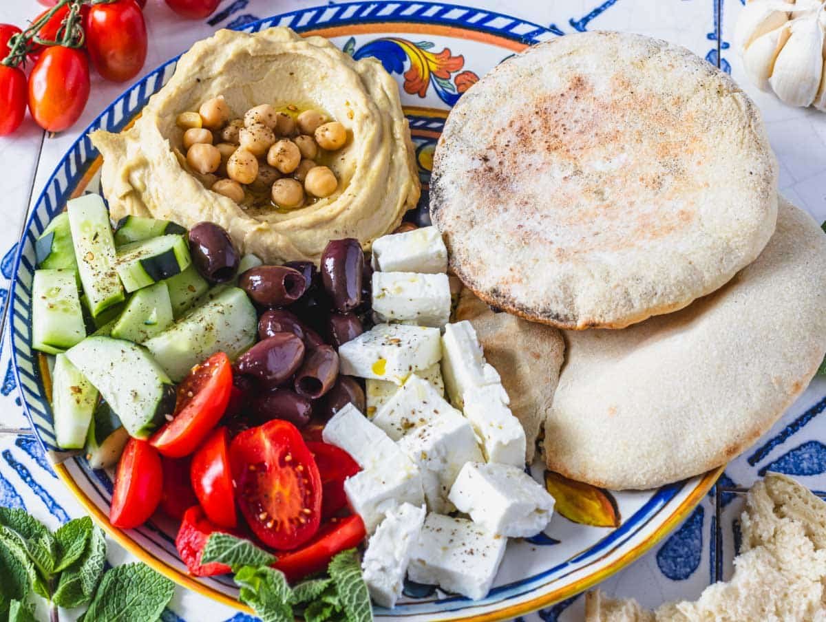 pita bread with hummus, feta, olives, and vegetables
