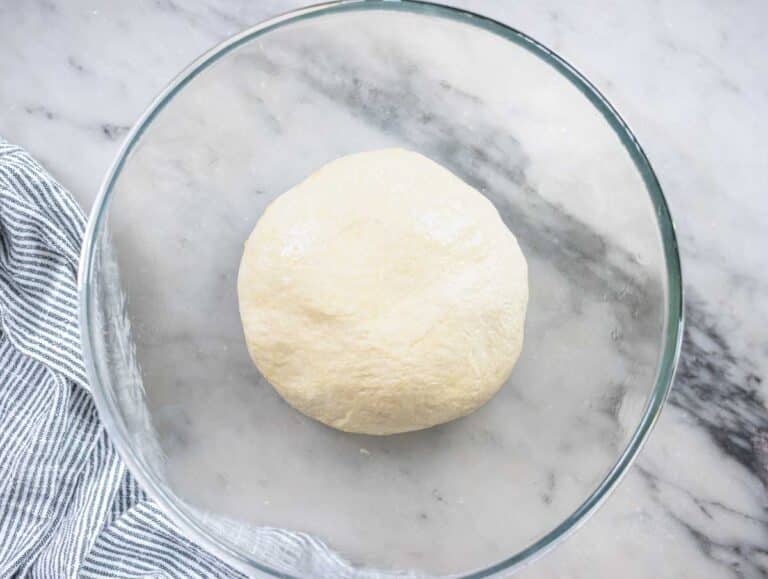 pita dough in a glass bowl before proofing
