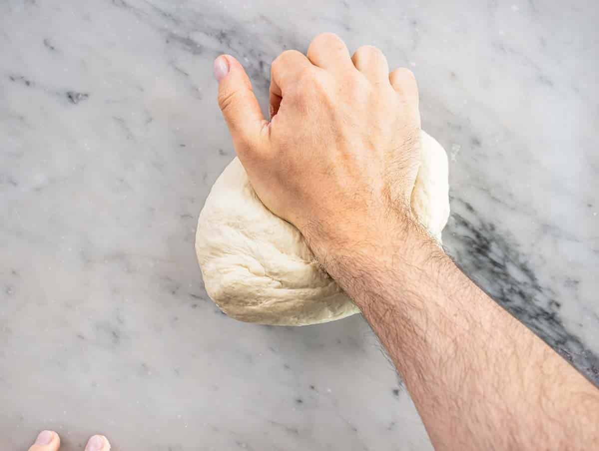 hand kneading a pizza dough