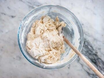 mixing flour, water, and yeast in a large mixing bowl