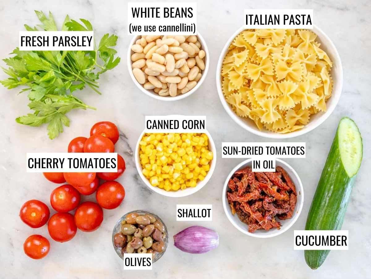 INGREDIENTS FOR VEGAN PASTA SALAD ON A MARBLE TABLE